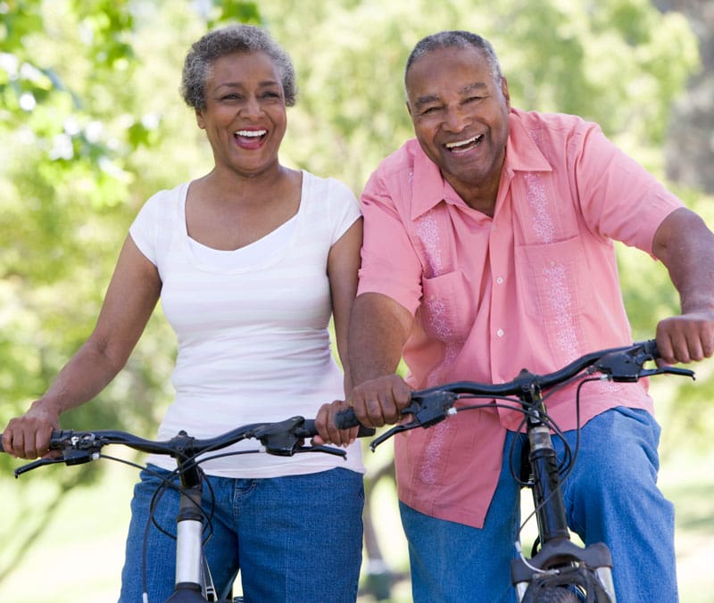 A Senior couple on a bike ride smiling